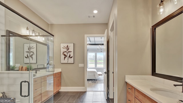 bathroom with a shower stall, baseboards, two vanities, and a sink