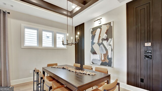 dining space featuring light wood finished floors, visible vents, and baseboards