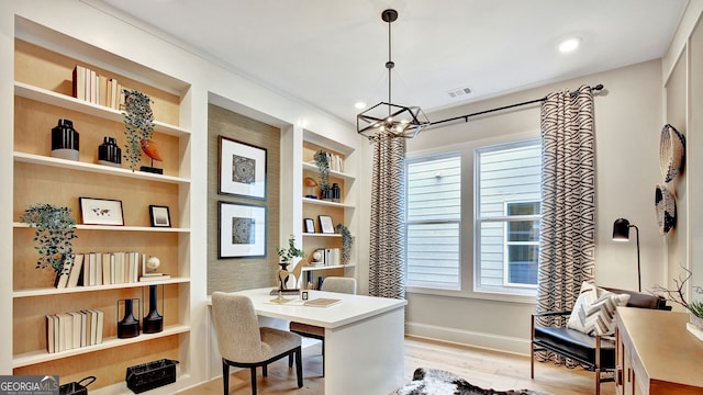 office area with built in features, baseboards, visible vents, wood finished floors, and a chandelier