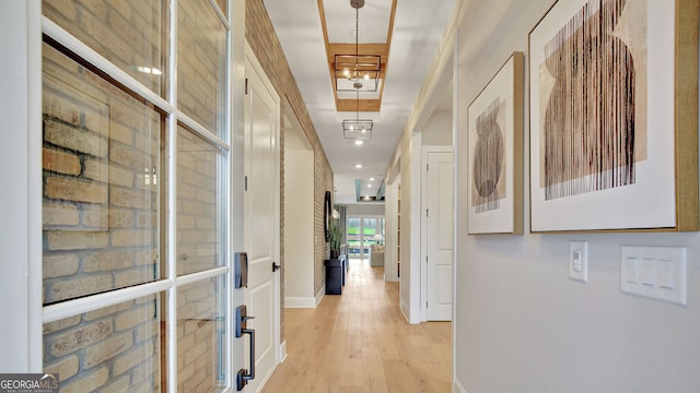 hallway featuring light wood-style flooring and baseboards