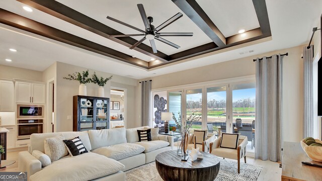 living area featuring beam ceiling, light wood finished floors, recessed lighting, a raised ceiling, and ceiling fan