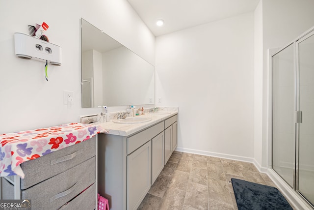 2030 Vidalia Ct, Dacula, GA 30019 - bathroom featuring double vanity, stone finish flooring, a stall shower, baseboards, and recessed lighting