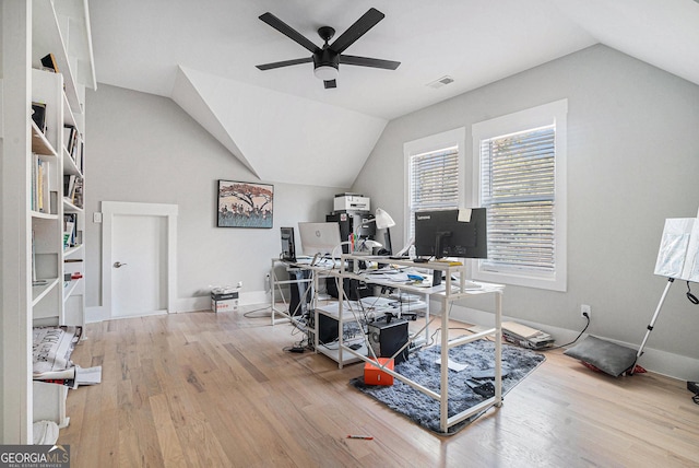 home office featuring a ceiling fan, lofted ceiling, wood finished floors, and visible vents