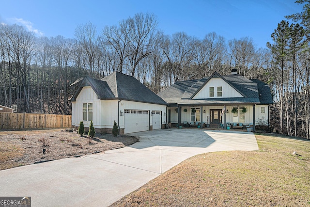 modern farmhouse featuring fence, a porch, an attached garage, a front lawn, and board and batten siding