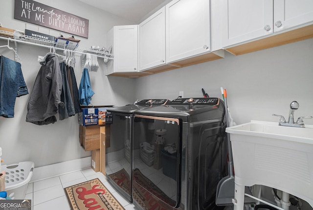 washroom featuring baseboards, cabinet space, a sink, tile patterned flooring, and washer and dryer