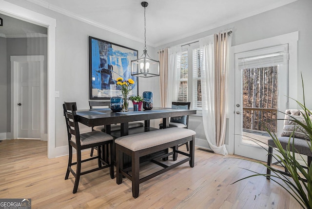 dining space with light wood finished floors, baseboards, and ornamental molding