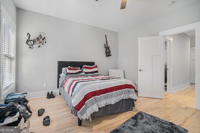 bedroom with ceiling fan, baseboards, and wood finished floors