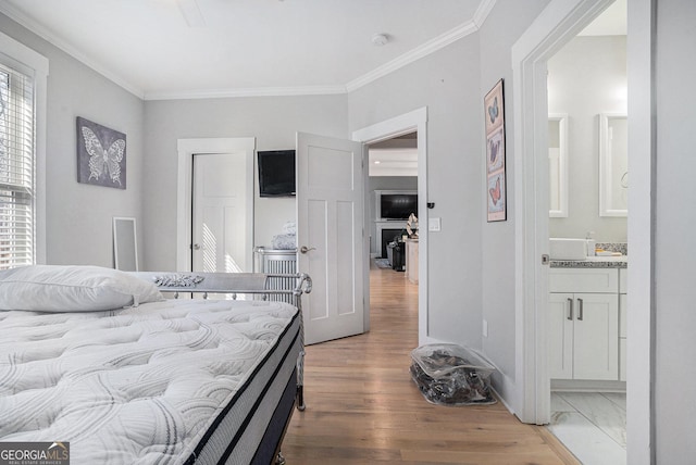 bedroom featuring light wood finished floors, connected bathroom, and ornamental molding