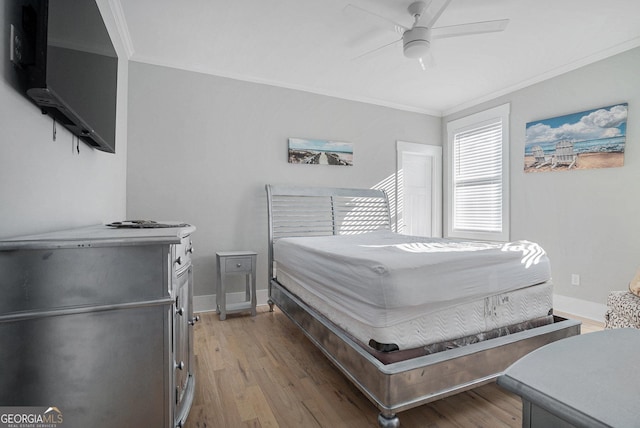 bedroom with light wood-style flooring, baseboards, and ornamental molding