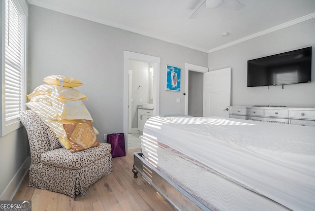 bedroom with light wood-type flooring, ensuite bathroom, crown molding, baseboards, and ceiling fan