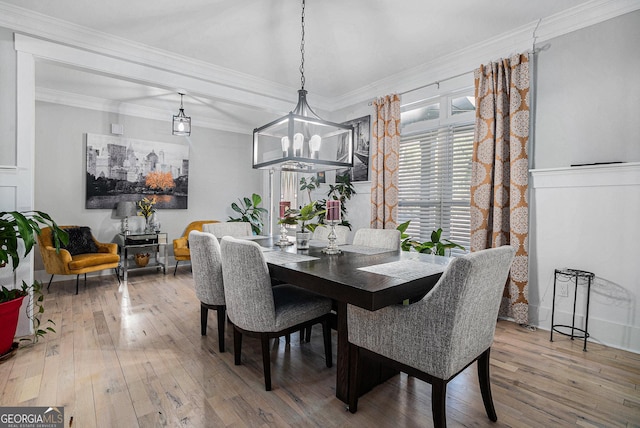 dining room featuring hardwood / wood-style floors, a chandelier, and ornamental molding