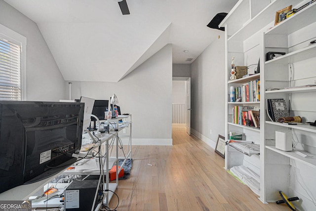 office space featuring vaulted ceiling, baseboards, and wood finished floors