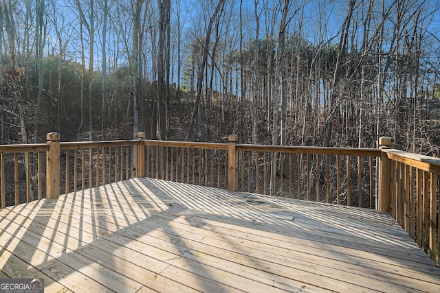 wooden deck featuring a forest view