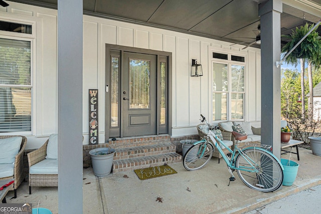 property entrance featuring covered porch, board and batten siding, and ceiling fan