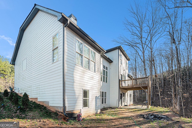 view of property exterior with a wooden deck