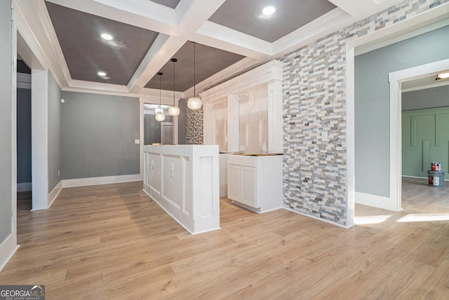 interior space with hanging light fixtures, coffered ceiling, light wood-type flooring, and ornamental molding