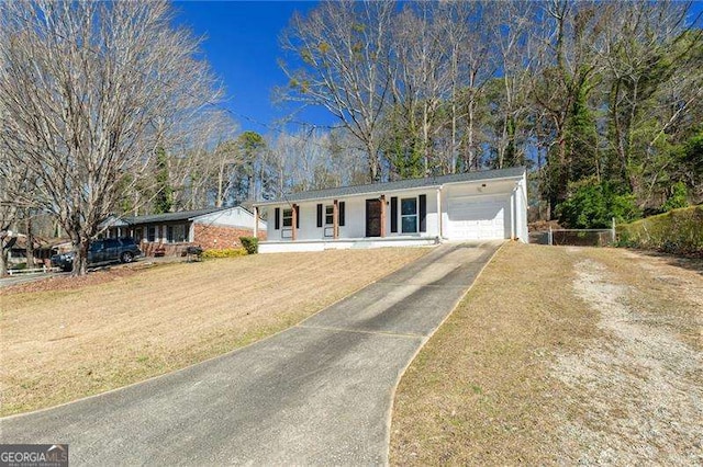 ranch-style house with covered porch, driveway, an attached garage, and a front yard