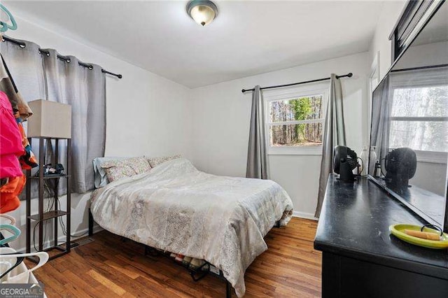 bedroom with baseboards and wood finished floors