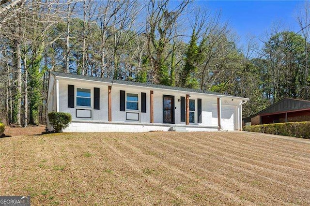 ranch-style home with a garage, brick siding, and a front yard