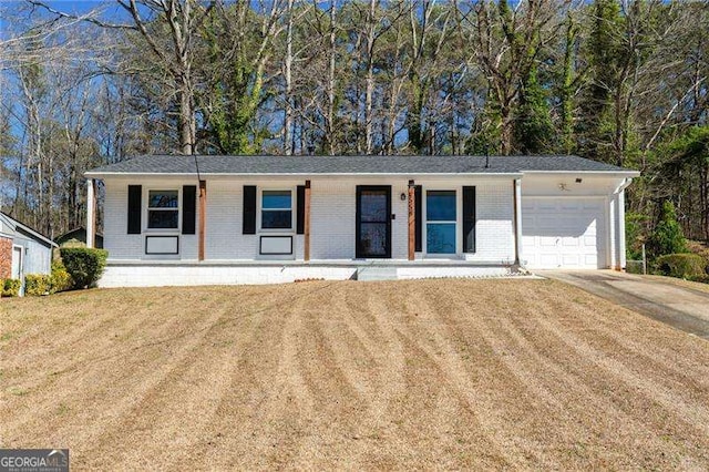 ranch-style home with an attached garage, covered porch, brick siding, concrete driveway, and a front yard