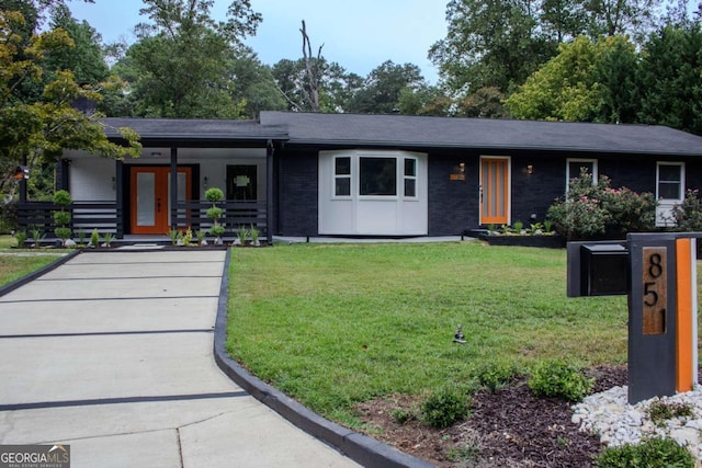 view of front of house with brick siding and a front lawn