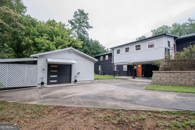 view of front of house with a garage, driveway, and an outdoor structure