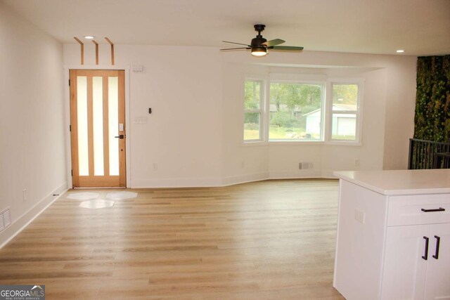 unfurnished living room featuring light wood-type flooring, baseboards, and recessed lighting