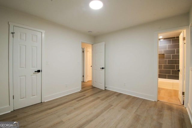 unfurnished bedroom with baseboards, a closet, and light wood-style floors