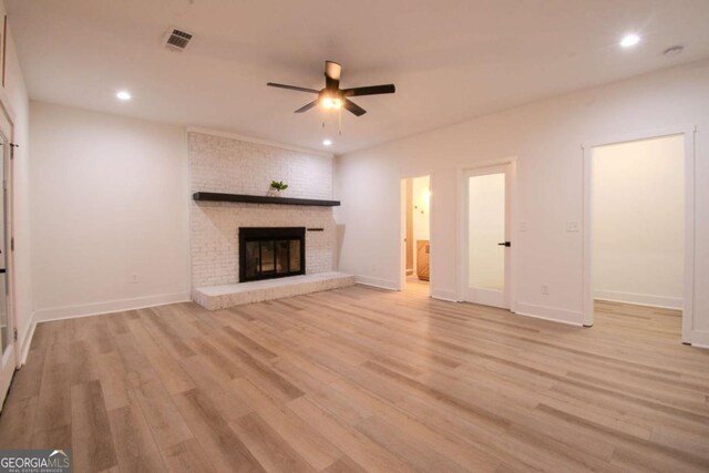 unfurnished living room featuring ceiling fan, recessed lighting, visible vents, light wood-type flooring, and a brick fireplace