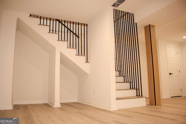 stairway featuring recessed lighting, visible vents, baseboards, and wood finished floors