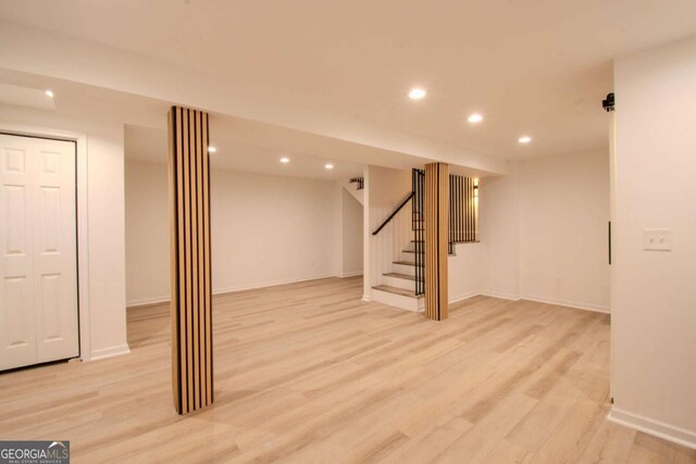 finished basement featuring stairs, recessed lighting, baseboards, and light wood-style floors