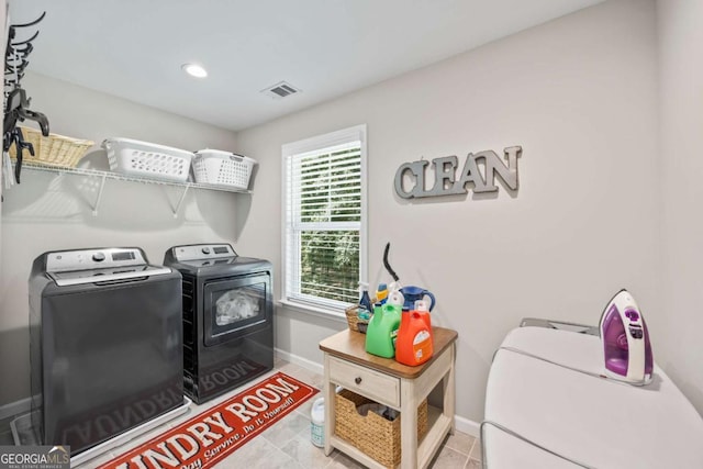 laundry area featuring visible vents, washing machine and dryer, light tile patterned flooring, laundry area, and baseboards