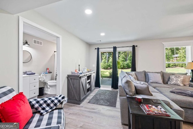 living room with light wood finished floors, visible vents, and recessed lighting