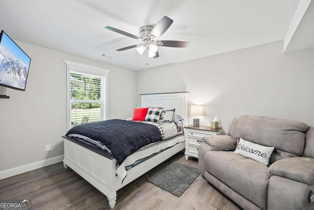 bedroom with dark wood-style floors, ceiling fan, and baseboards