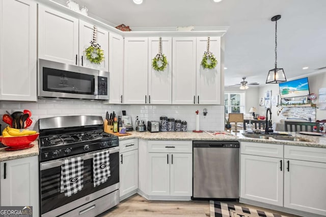 kitchen featuring tasteful backsplash, appliances with stainless steel finishes, white cabinetry, a sink, and recessed lighting