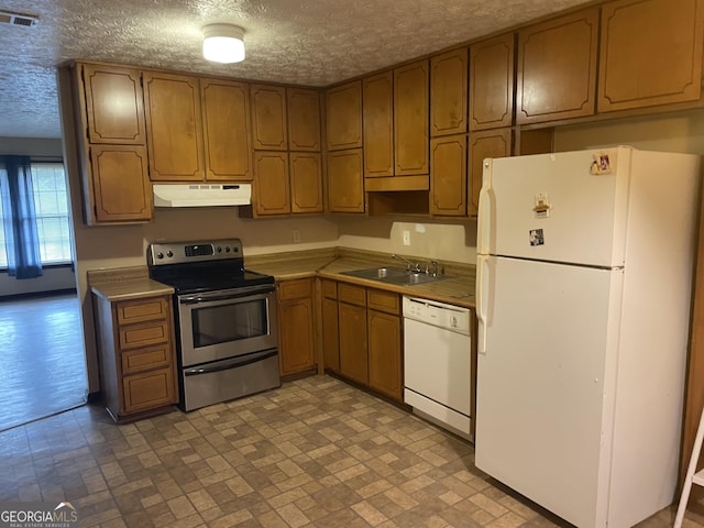 405415 Chase Dr, Fayetteville, GA 30214 - kitchen with white appliances, under cabinet range hood, brick patterned floors, a textured ceiling, and brown cabinetry