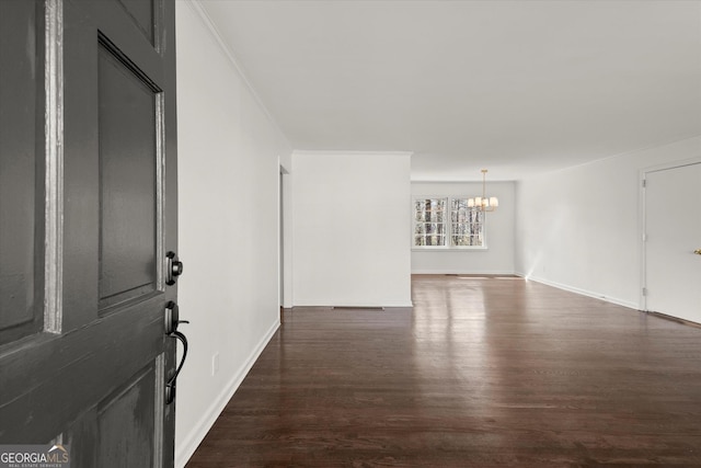 foyer featuring baseboards, a chandelier, and dark wood-style flooring