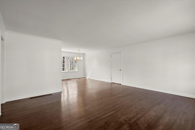 unfurnished living room with visible vents, baseboards, ornamental molding, dark wood-type flooring, and an inviting chandelier