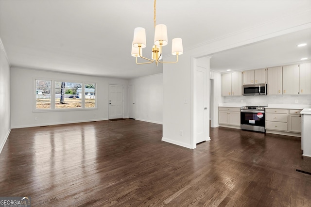 unfurnished living room with visible vents, baseboards, dark wood-style flooring, a notable chandelier, and recessed lighting