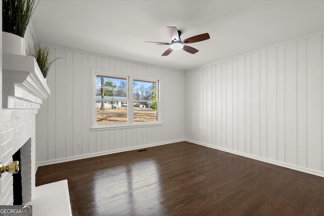 unfurnished living room with visible vents, baseboards, a ceiling fan, dark wood-type flooring, and a brick fireplace