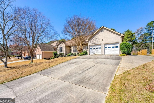 ranch-style house featuring concrete driveway, an attached garage, and stucco siding