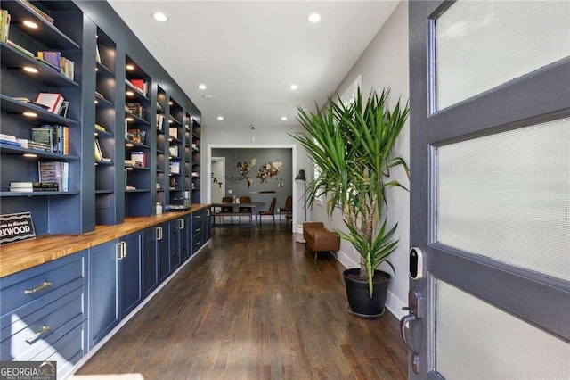 wine area with dark wood-style floors, recessed lighting, built in shelves, and baseboards