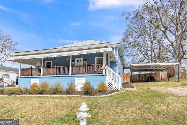 view of front of property featuring metal roof, a porch, a front lawn, and fence