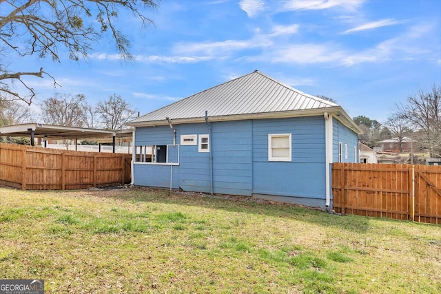 back of property with fence, metal roof, and a lawn