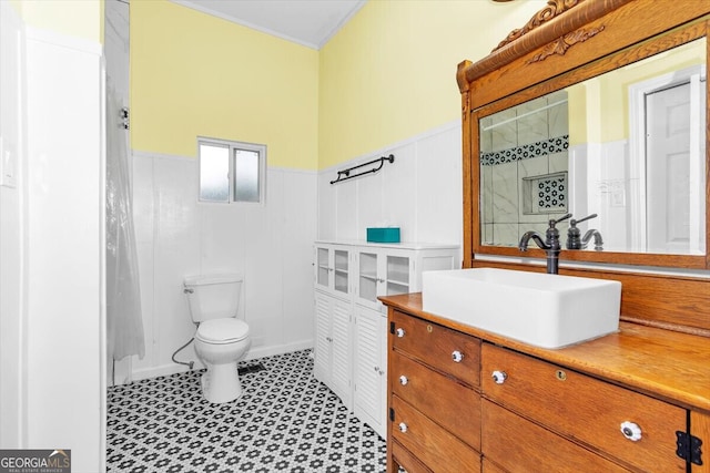 full bathroom featuring a wainscoted wall, vanity, and toilet