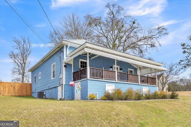 exterior space featuring central air condition unit, a porch, metal roof, fence, and a front lawn