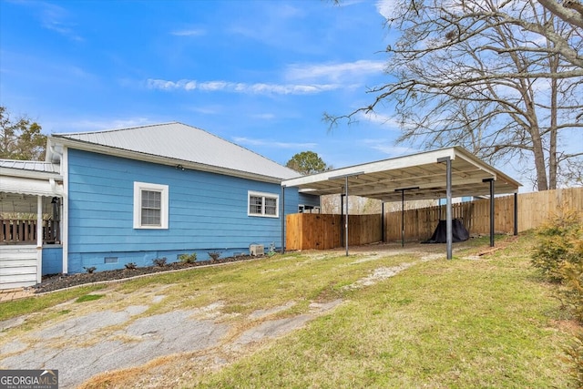 back of house with a yard, metal roof, fence, and crawl space