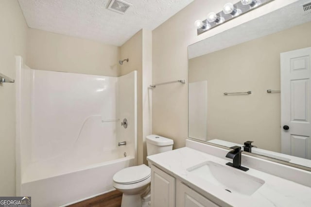 full bathroom with toilet, visible vents, a textured ceiling, and bathing tub / shower combination