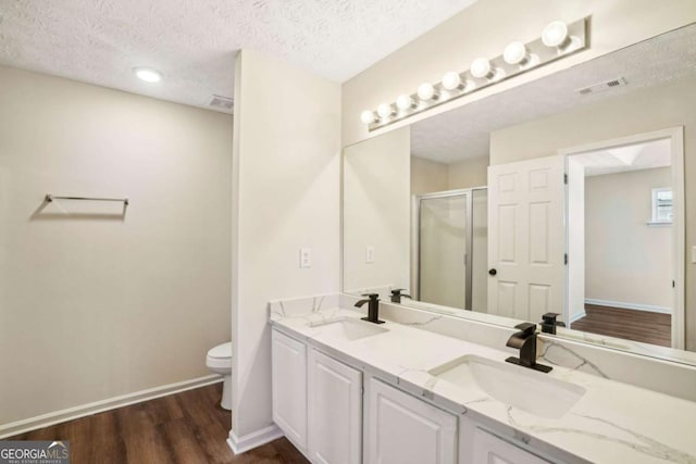 full bath with a stall shower, visible vents, a sink, and wood finished floors