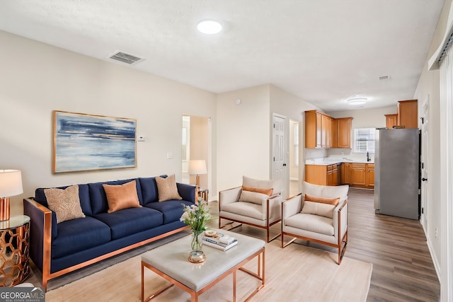 living room featuring light wood-style floors and visible vents